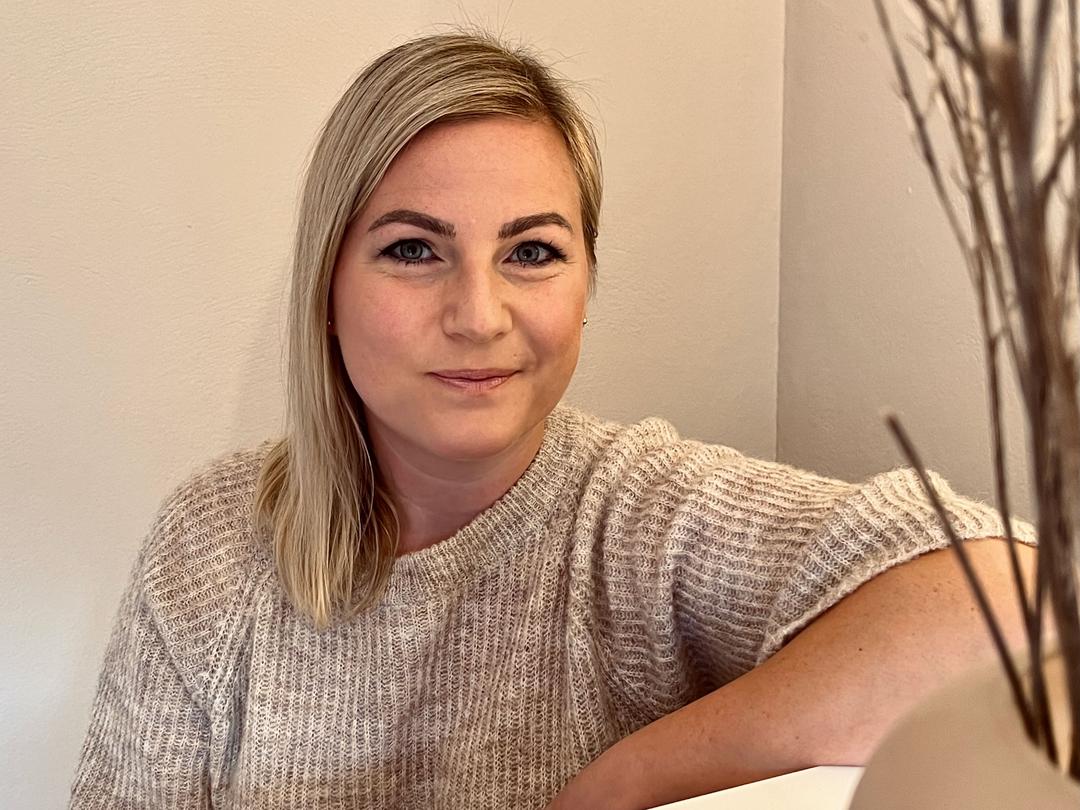 Maike angelehnt an ihrem Empfangstresen